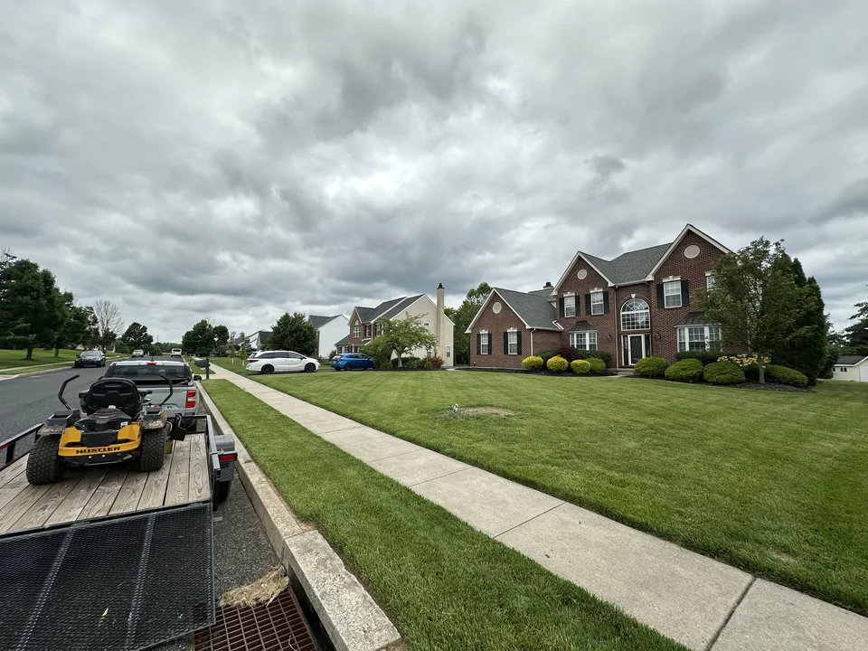 Freshly cut lawn in front of a brick house